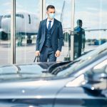 businessman-with-bag-hand-standing-near-glass-door-airport-looking-car-front-him-medical-mask-his-face