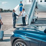 elegant-businessman-coming-plane-by-car-with-driver-shaking-hands-with-pilot-before-flight
