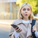 image-young-surprised-woman-standing-street-with-mobile-phone-looking-amazed-camera