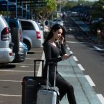 pretty-girl-listening-music-sitting-two-suitcases
