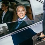senior-business-woman-her-assistant-sitting-limousine-talking-working