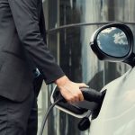 view-closeup-progressive-black-suit-businessman-recharge-battery-ev-car